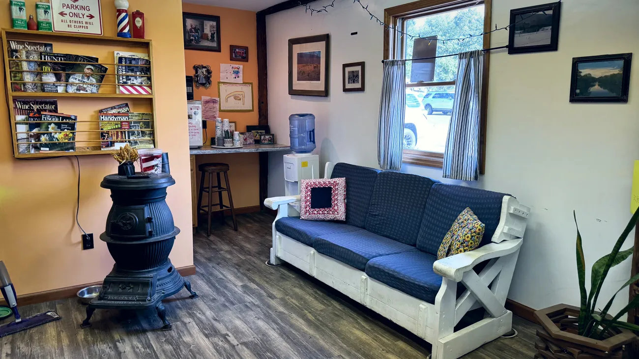 The waiting nook — a cast-iron stove, a magazine rack, and a worn bench by the window.