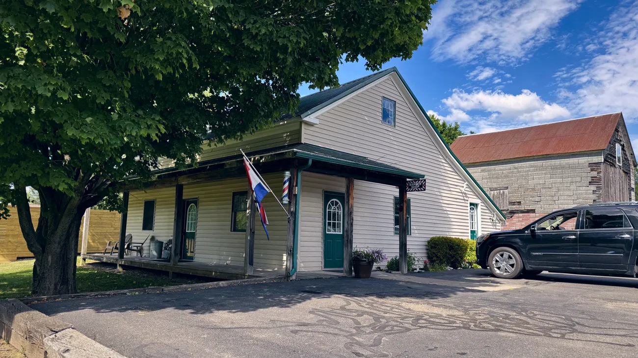 The covered front porch and green door of the shop.